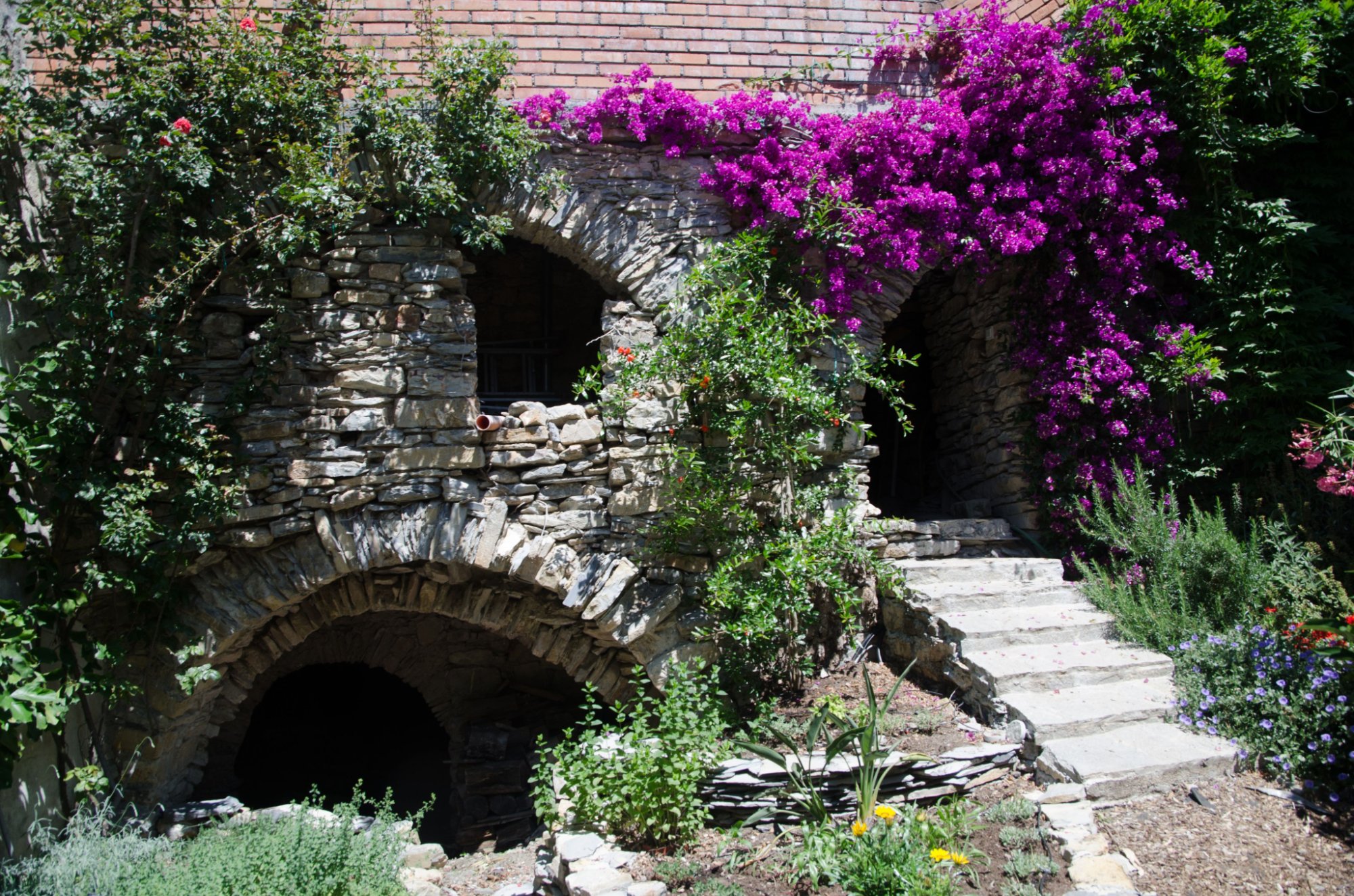 Steinbögen und Bougainvillea im Garten von Ca' Serena